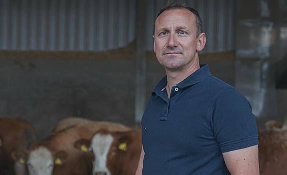 Farmer with cattle in barn